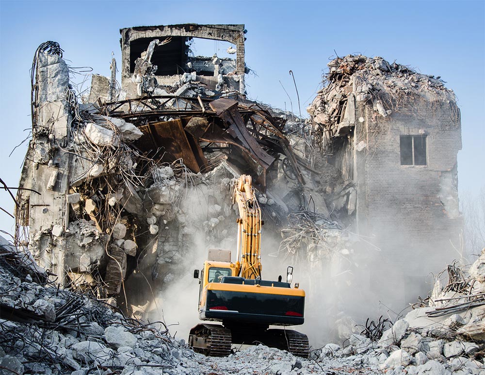 demolition bonds - show an excavator demolishing a building